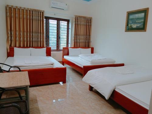 a room with two beds and a table at Hien Thuc Hotel in Ninh Binh