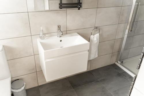 a bathroom with a white sink and a shower at Cosy 2 bed cottage in charming village of Christleton - For up to 5 in Christleton