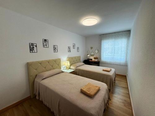 サロウにあるApartamento Barbastroのベッド2台と窓のある寝室