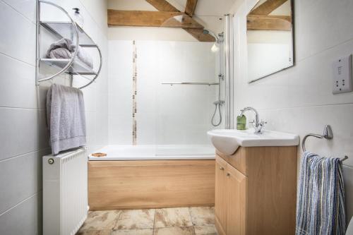 a bathroom with a sink and a bath tub at Thyme Lodge Drefach Felindre in Felindre