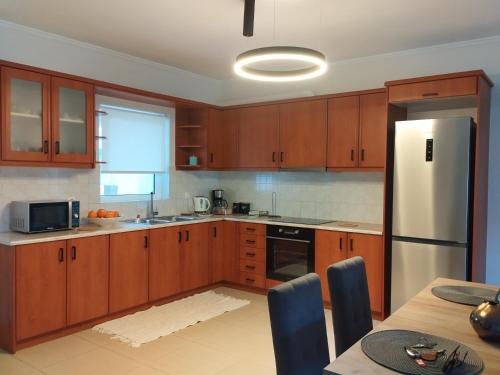 a kitchen with wooden cabinets and a white refrigerator at Chrysa's Luxury Apt. View of Palamidi in Nafplio
