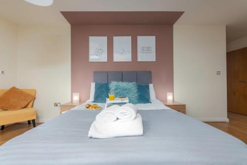 ein Schlafzimmer mit einem Bett mit Handtüchern darauf in der Unterkunft Cozy 2BR Retreat | Prime Cardiff Location in Cardiff