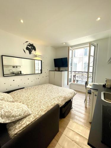 une chambre avec un lit et une grande fenêtre dans l'établissement Studio hyper centre ( 1-2 ), à Marseille