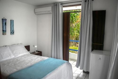 a bedroom with a bed and a sliding glass door at Hotel Pousada Estacao Do Sol Natal in Natal