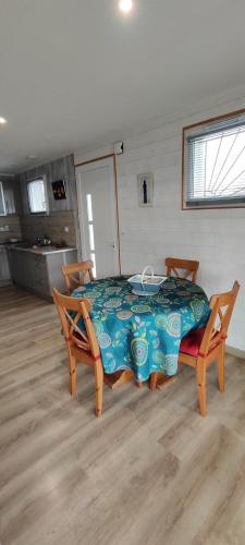 une chambre avec une table et deux chaises ainsi qu'une cuisine dans l'établissement L'annexe de la Villa Darom, Andernos les bains., à Andernos-les-Bains