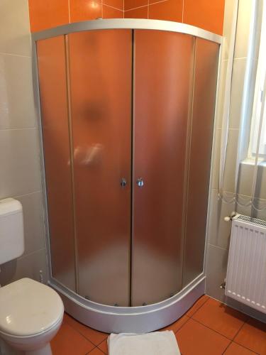 a shower stall in a bathroom with a toilet at Major Panzió és Étterem in Hajdúszoboszló