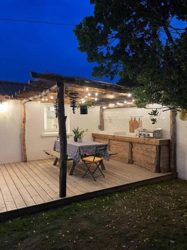 une terrasse en bois avec une table de pique-nique et une table dans l'établissement Chez Claude / Spa privatif, à Saint-Jean-de-Monts