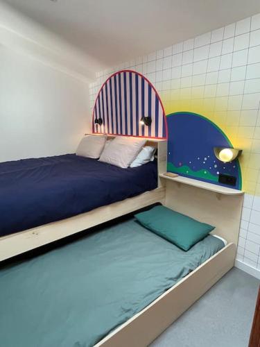 une chambre avec deux lits superposés et un lit avec une tête de lit dans l'établissement Chez Claude / Spa privatif, à Saint-Jean-de-Monts