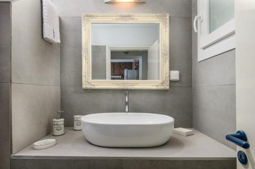 a bathroom with a large white sink and a mirror at Skinopi Beach Guesthouse in Schinopi