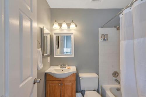 a white bathroom with a sink and a toilet at 2 Units Side-By-Side Sleeps 24 in Tower Grove