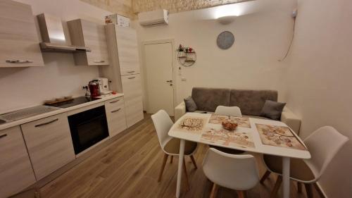 una pequeña cocina con mesa y sillas en una habitación en La Dimora di Venere, en Castellana Grotte