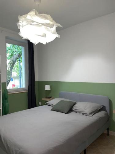 um quarto com uma cama com um lustre e uma janela em Appartement central à Castelnaudary em Castelnaudary
