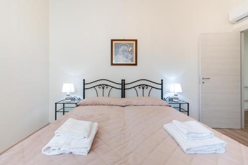 a bedroom with a large bed with two towels on it at Oltretorrente Ospedale Apartment in Parma