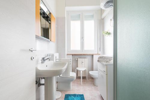 a bathroom with a sink and a toilet and a window at Oltretorrente Ospedale Apartment in Parma