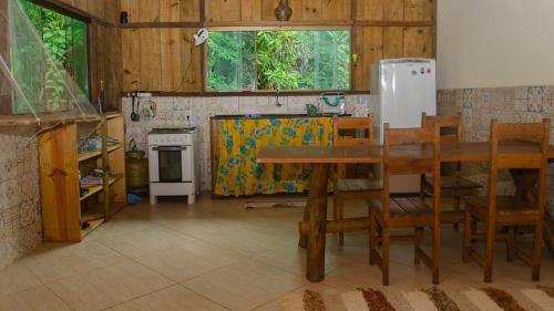 cocina con mesa y nevera en Sitio recanto da natureza en Serra Grande