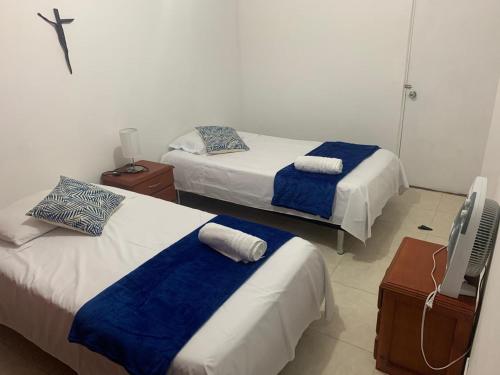 1 dormitorio con 2 camas y TV. en Apartamento confortable, cerca a la Basílica, en Buga