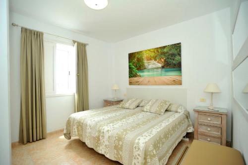 una camera da letto con un letto e un dipinto sul muro di One bedroom appartement with terrace and wifi at San Cristobal de La Laguna a La Laguna
