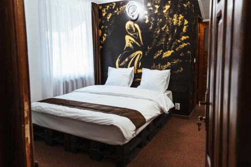 a bedroom with a bed with a painting on the wall at Casa Rosu in Cluj-Napoca