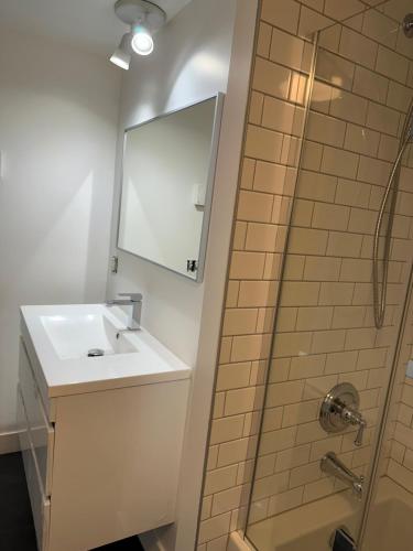 uma casa de banho com um lavatório e um chuveiro em L'appartement BOHO avec parking em Cidade de Quebec