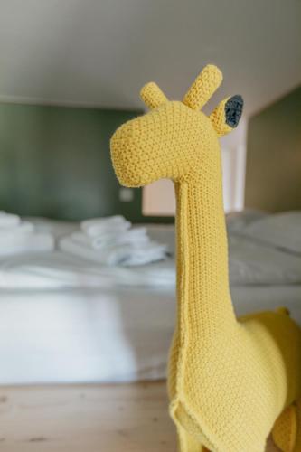 a toy giraffe standing in front of a bed at Superbe appartement avec piscine in Nendaz