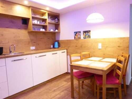 cocina con mesa de madera, sillas y fregadero en ASENATA Ustroń Centrum en Ustroń