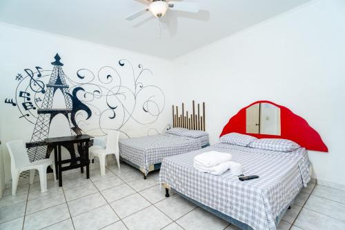 拉塞瓦的住宿－hotel trinidad，一间卧室配有两张床和一张带红伞的桌子