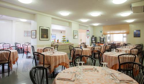 a dining room with tables and chairs in a room with at HOTEL AZZURRA in Senigallia