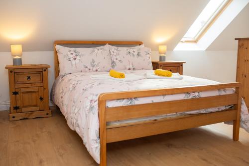 een slaapkamer met een bed met twee gele voorwerpen erop bij Tudor Cottage Manorbier in Manorbier
