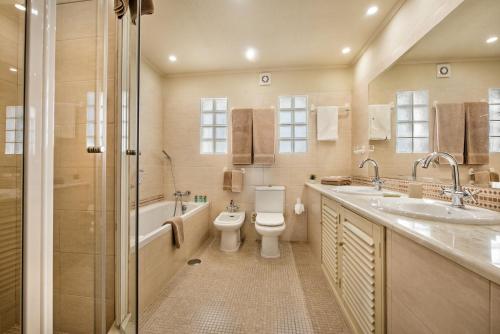 een badkamer met een toilet, een wastafel en een douche bij Mng Elliott37 in Vale do Lobo