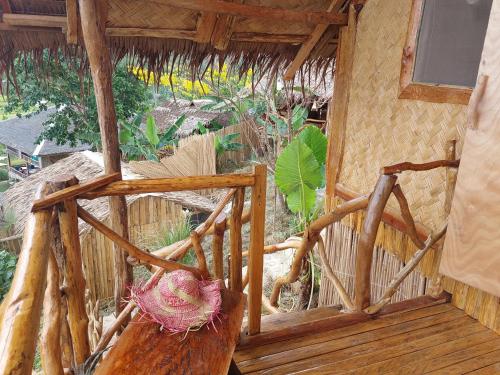 a wooden porch of a house with a thatch roof at Jungle Bar Honeymoon suite & private pool in San Vicente