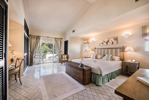 een slaapkamer met een groot bed, een tafel en een bureau bij Mng Elliott37 in Vale do Lobo