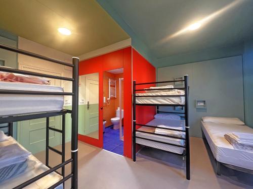 a room with three bunk beds and a bathroom at Loop INN Hostel Santiago de Compostela in Santiago de Compostela