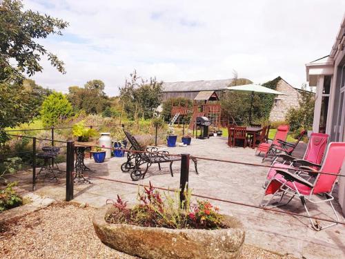 d'une terrasse avec des chaises, une table et des chaises. dans l'établissement Grove Cottage at The Lodge, à Tullow