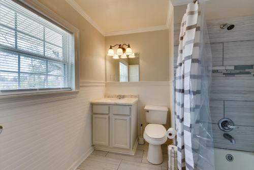 a bathroom with a toilet and a sink and a mirror at Charming Lake Charles Apartment 2 Mi to Lake! in Lake Charles