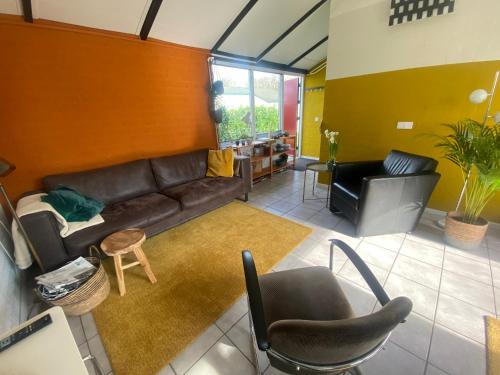 辛佩爾費爾德的住宿－Zuid Limburg Huisje Josefien，客厅配有真皮沙发和椅子