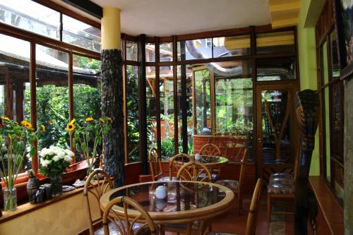 a dining room with tables and chairs and windows at Hotel y Spa Isla de Baños in Baños