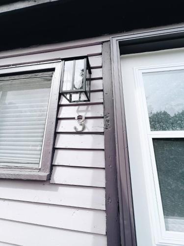 a window and a door on a house at Cottage Feels in the City - Downtown Apartment & Backyard Bliss in Fredericton