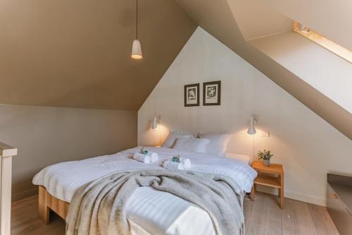 um quarto com uma grande cama branca num sótão em Bonrepo Room 104 em Bruges