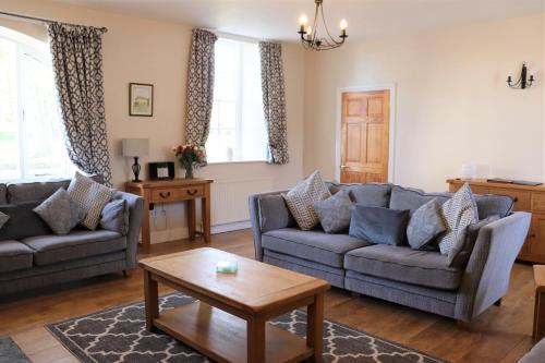 ein Wohnzimmer mit 2 Sofas und einem Couchtisch in der Unterkunft Portclew Cottages in Pembroke