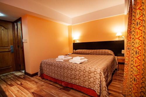 a hotel room with a bed with towels on it at Hotel Villa Brescia in Ushuaia