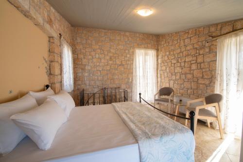 um quarto com uma cama e uma parede de tijolos em Mira Mare em Khlóï