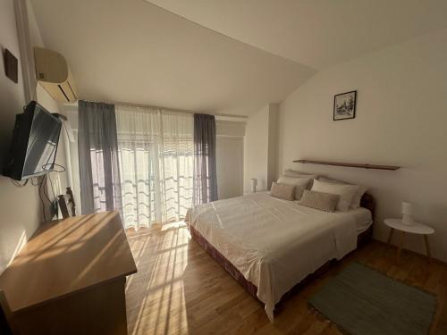 a bedroom with a bed and a large window at Pension Rušev in Preko
