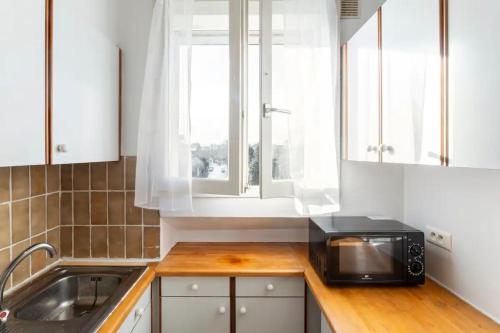 a kitchen with a sink and a microwave on a counter at Charmant appartement pour 3 personnes à Bagneux in Bagneux