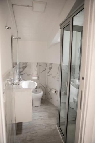 a white bathroom with a toilet and a sink at Dreams in Gragnano