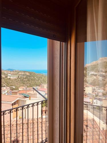 a window in a room with a view of the ocean at B&B Aria Ona in Villagrande Strisaili