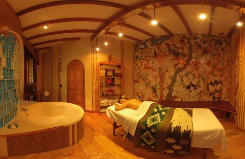 een slaapkamer met een bad en een bed en een bad bij Hotel y Spa Isla de Baños in Baños