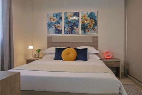 a bedroom with a bed with a yellow pillow on it at Zeta - Garden Oasis with Private Parking in Katerini