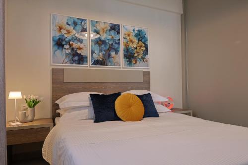 a bedroom with a white bed with blue and yellow pillows at Zeta-Garden Oasis & Private Parking by Optimum Link in Katerini