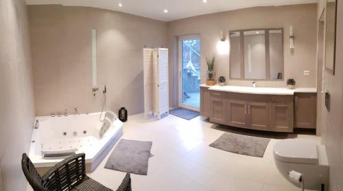 ein Badezimmer mit einer Badewanne, einem Waschbecken und einem WC in der Unterkunft Chill Sun in Arendal