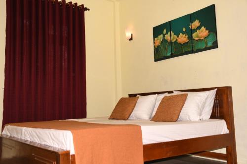 1 dormitorio con 1 cama con cortina roja en Leaf Dew Resort en Anuradhapura